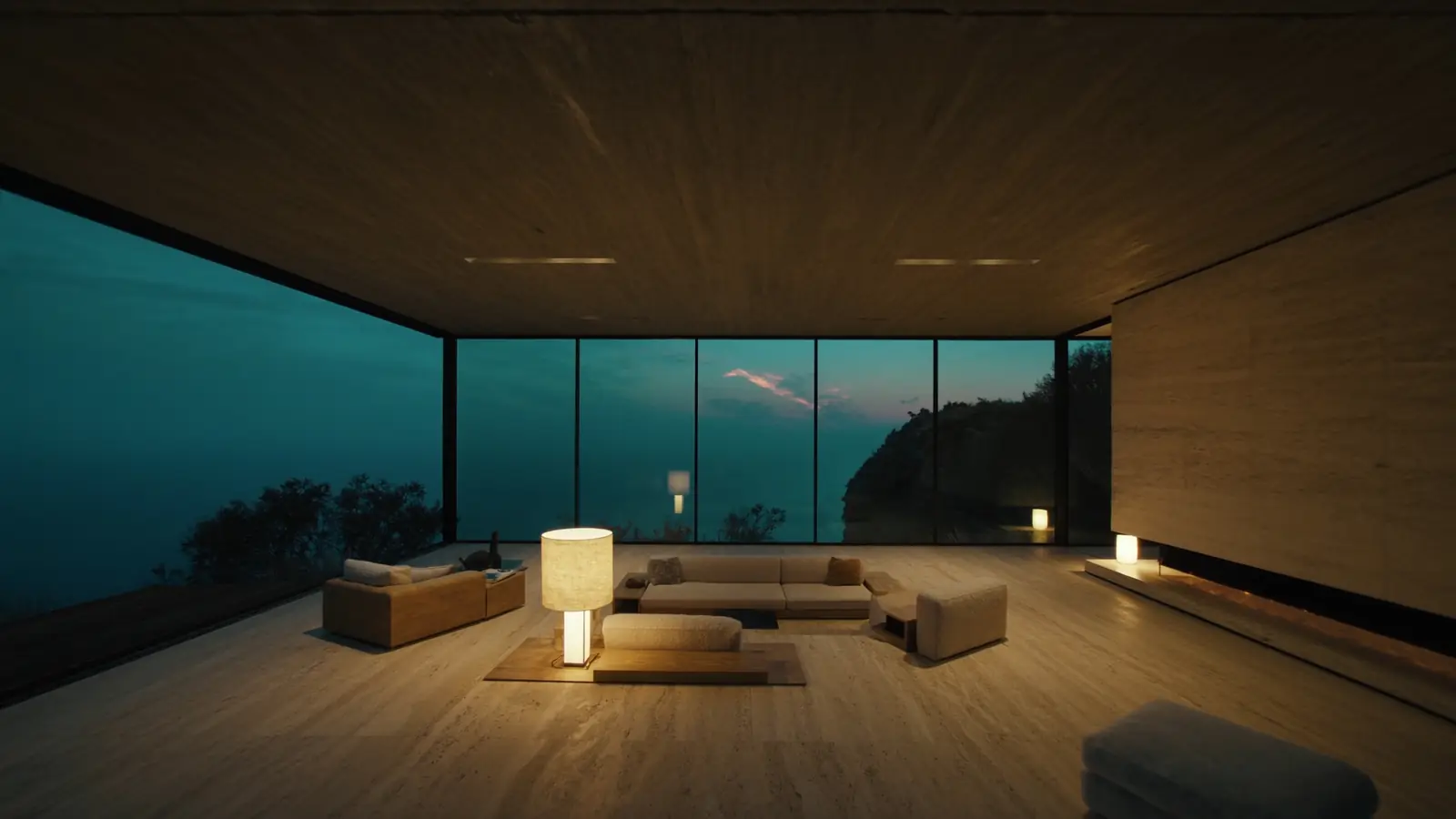 Inside the pavilion: a travertine floor, low lamps and a glass wall framing the ocean